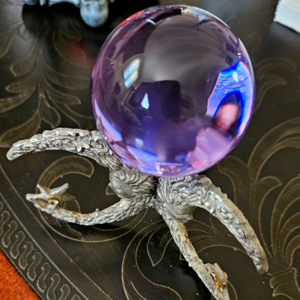 Small crystal ball with pewter stand.